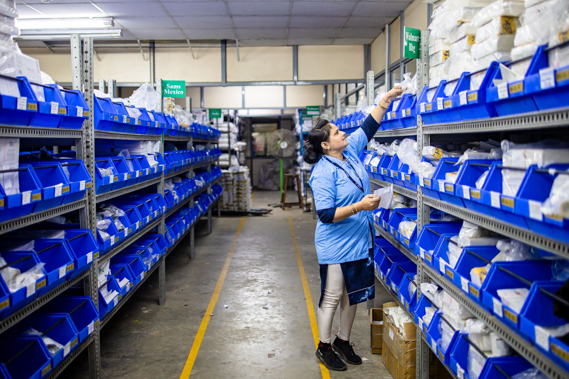 Workers inside a large logistics and shipping warehouse