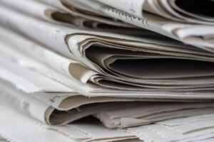 Close-up of a newspaper printing press rolling out fresh pages