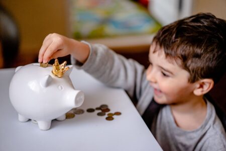 Treasury Names Funds Eligible for Children’s Trump Accounts A piggy bank beside coins representing children's savings accounts
