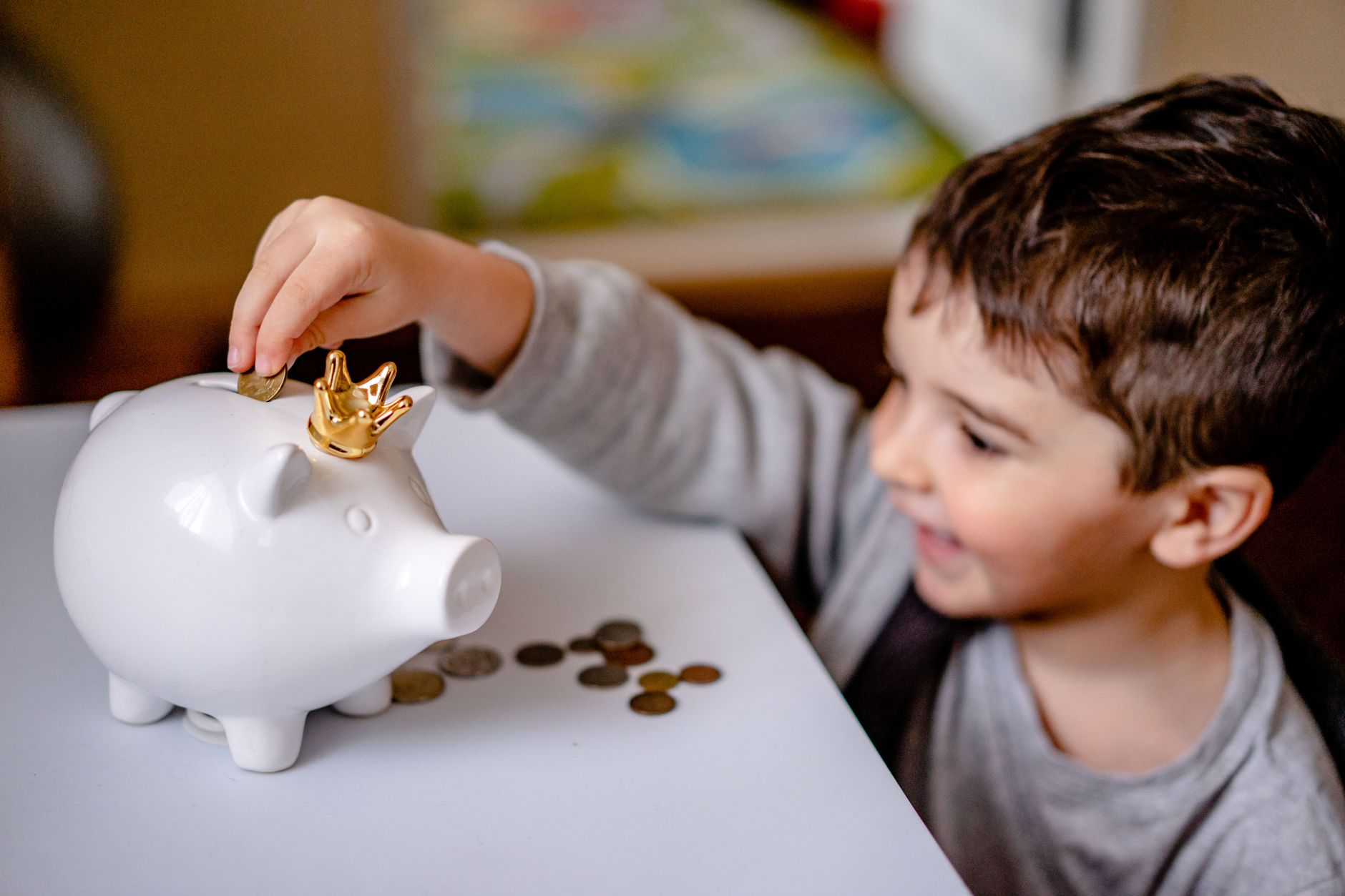 A piggy bank beside coins representing children's savings accounts