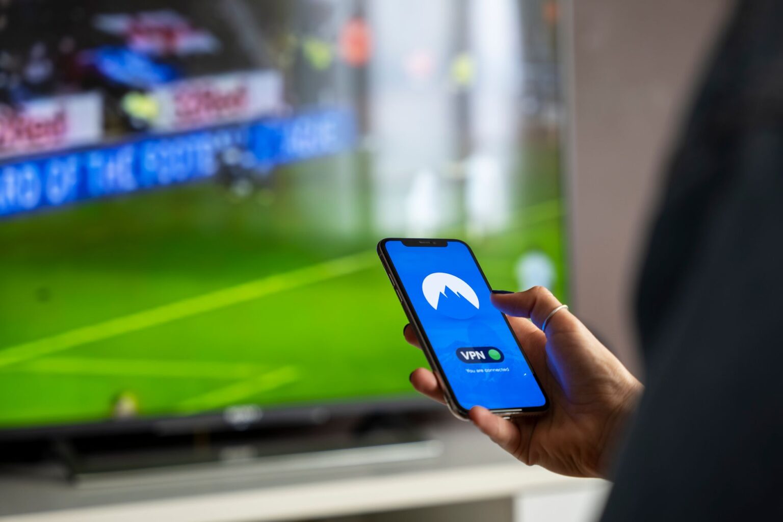 Netflix Bets on Live Sports as Investors Question Engagement Numbers Person holding a remote control in front of a streaming television screen