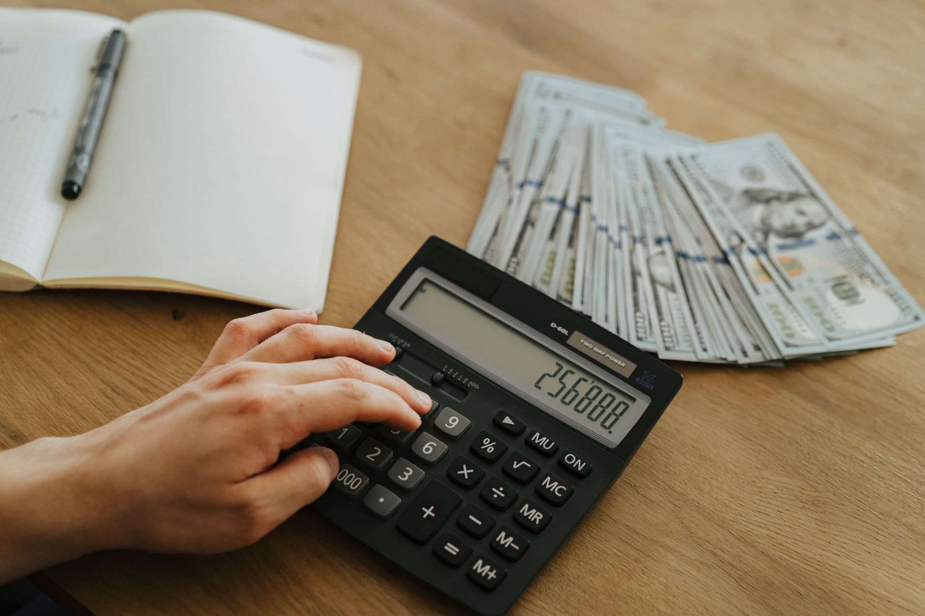 Calculator and financial documents representing fund expense ratio comparison