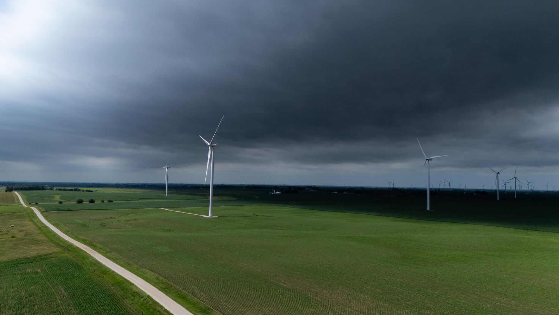 Wind turbines in an open field representing clean energy projects facing funding cuts