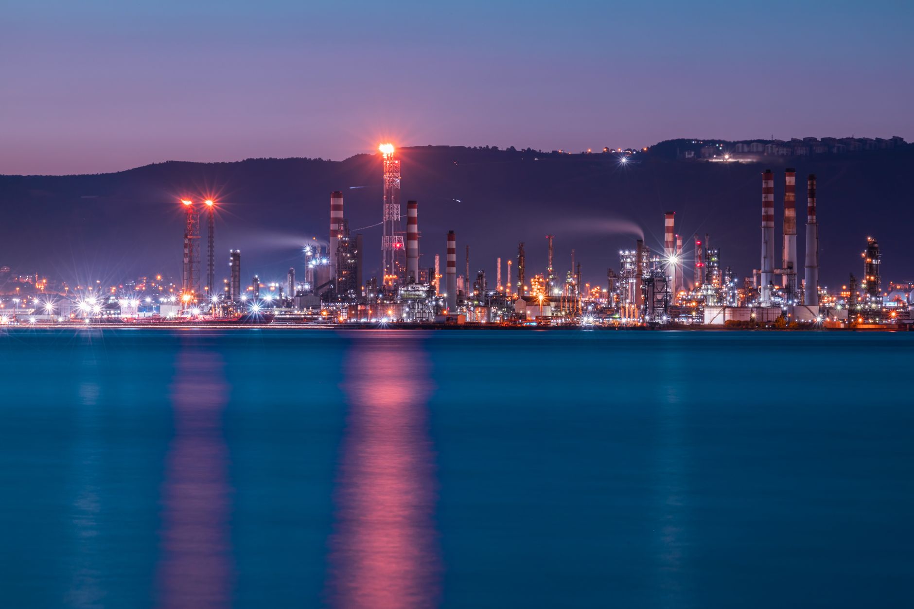 Oil refinery at night representing rising crude prices after Middle East missile strike