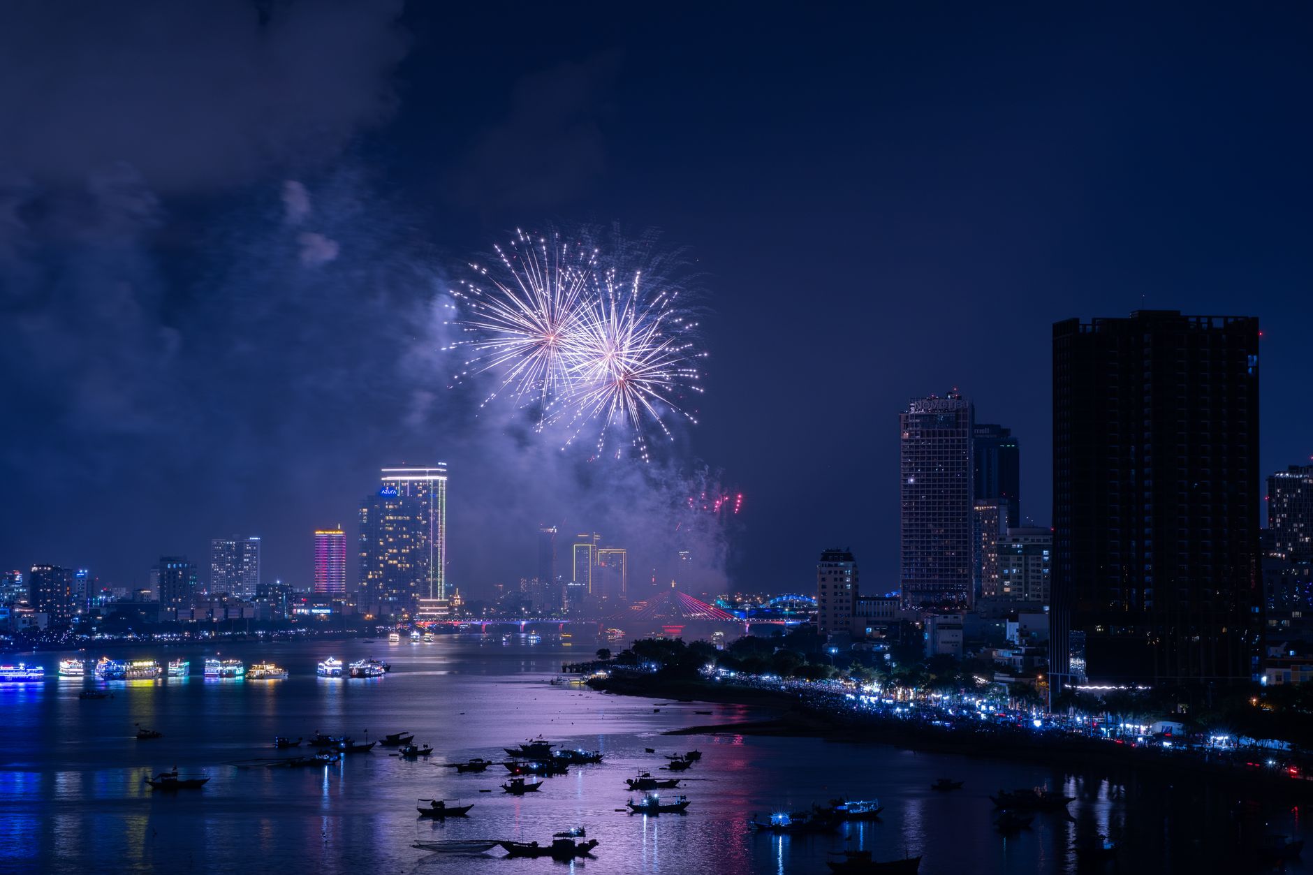 Fireworks display lighting up the sky over a city waterfront