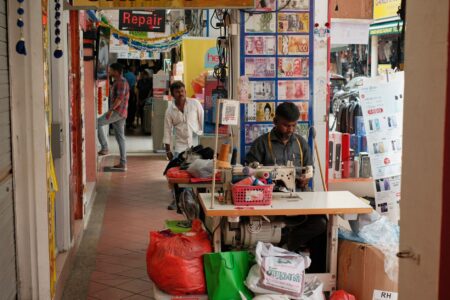 Clothing Retailers Add Repair Counters to Win Over Budget-Minded Gen Z A tailor repairing a jacket inside a clothing store