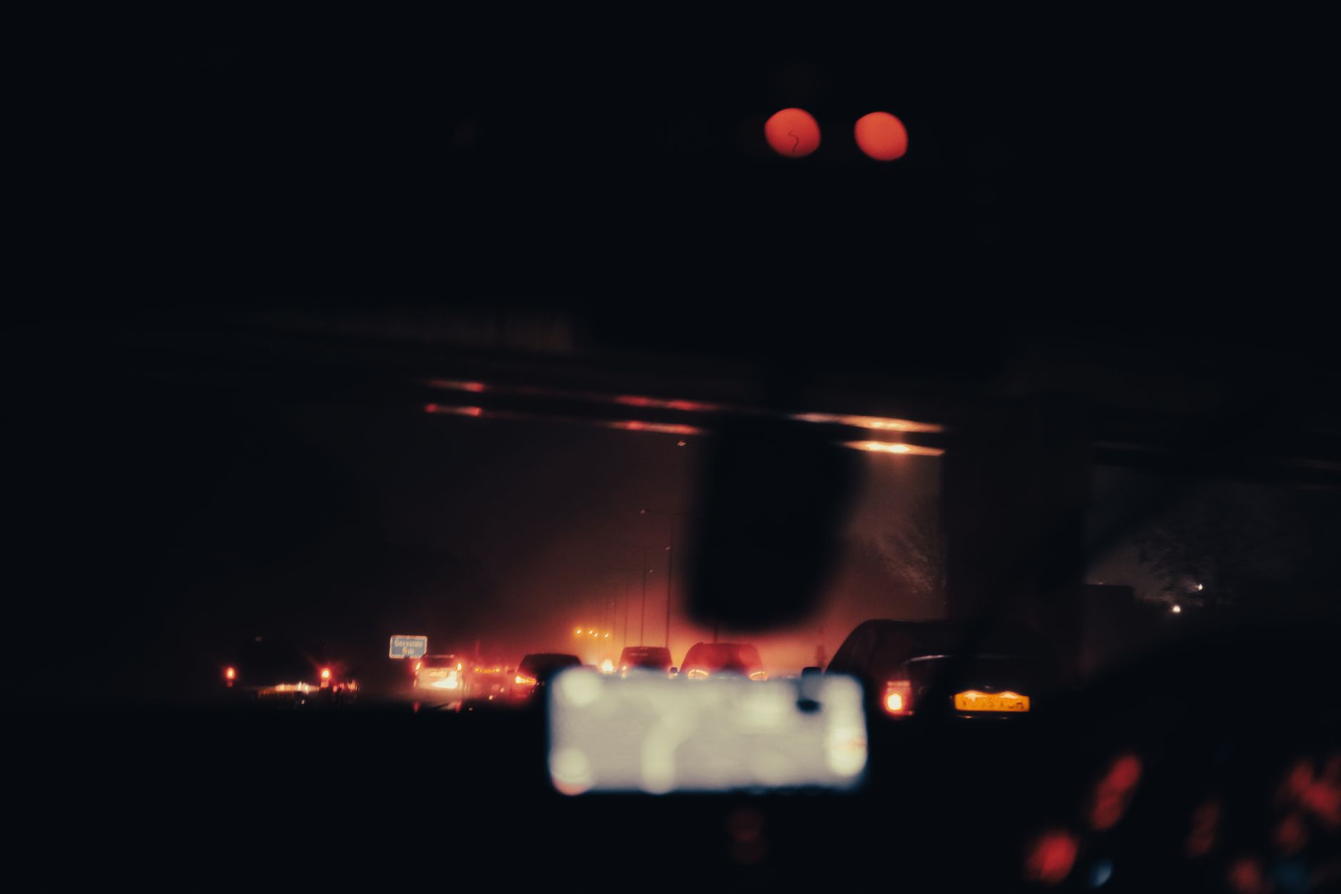 Bright car headlights illuminating a dark road at night