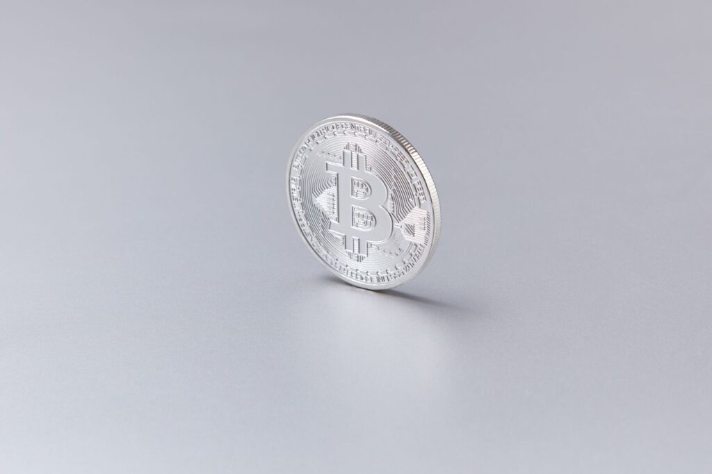 A physical bitcoin coin resting on a financial chart showing price movement