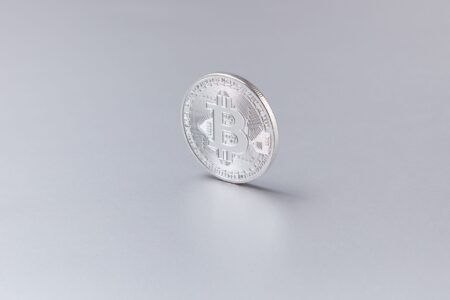 A physical bitcoin coin resting on a financial chart showing price movement