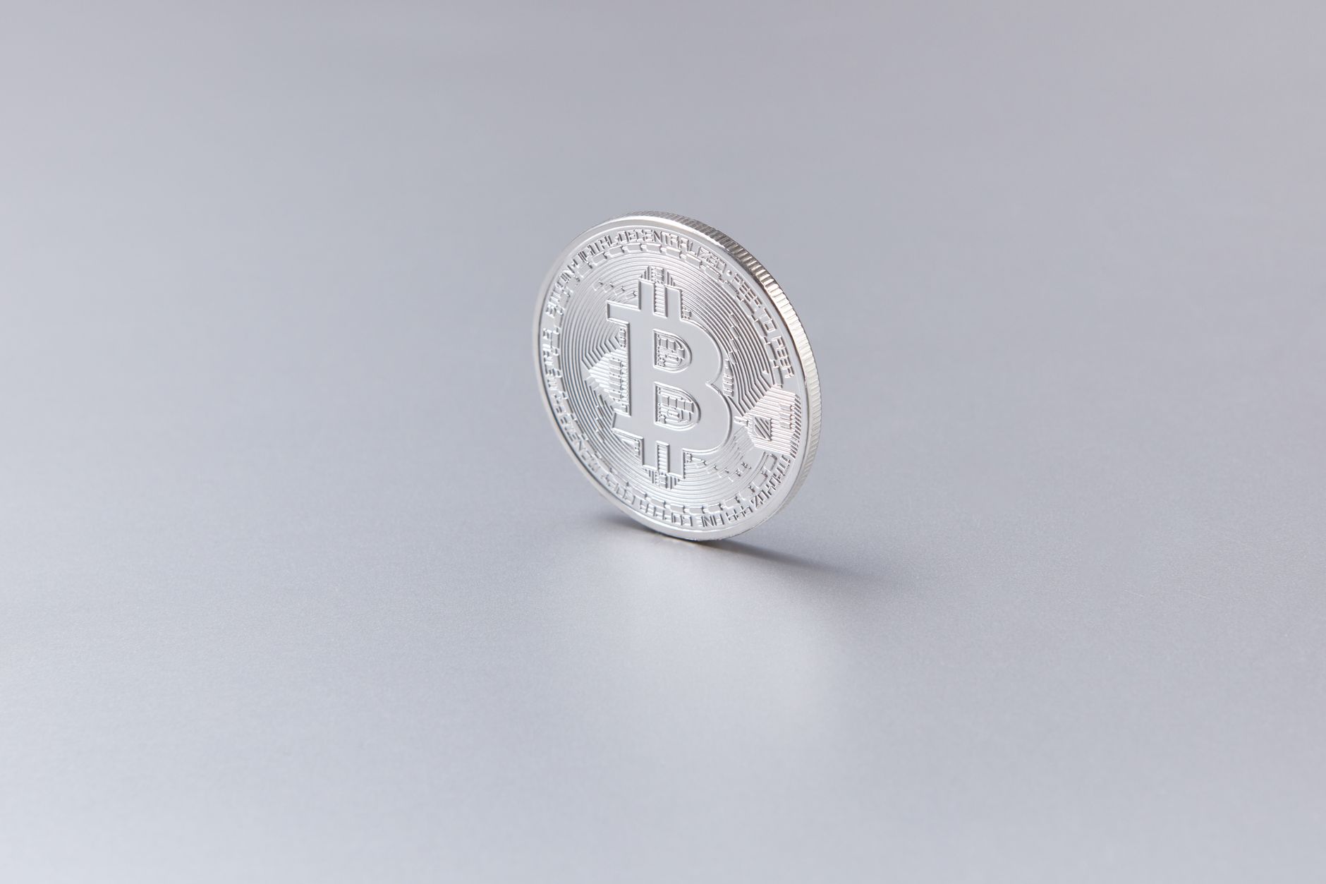 A physical bitcoin coin resting on a financial chart showing price movement