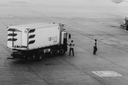 Ground crew workers on airport tarmac near aircraft