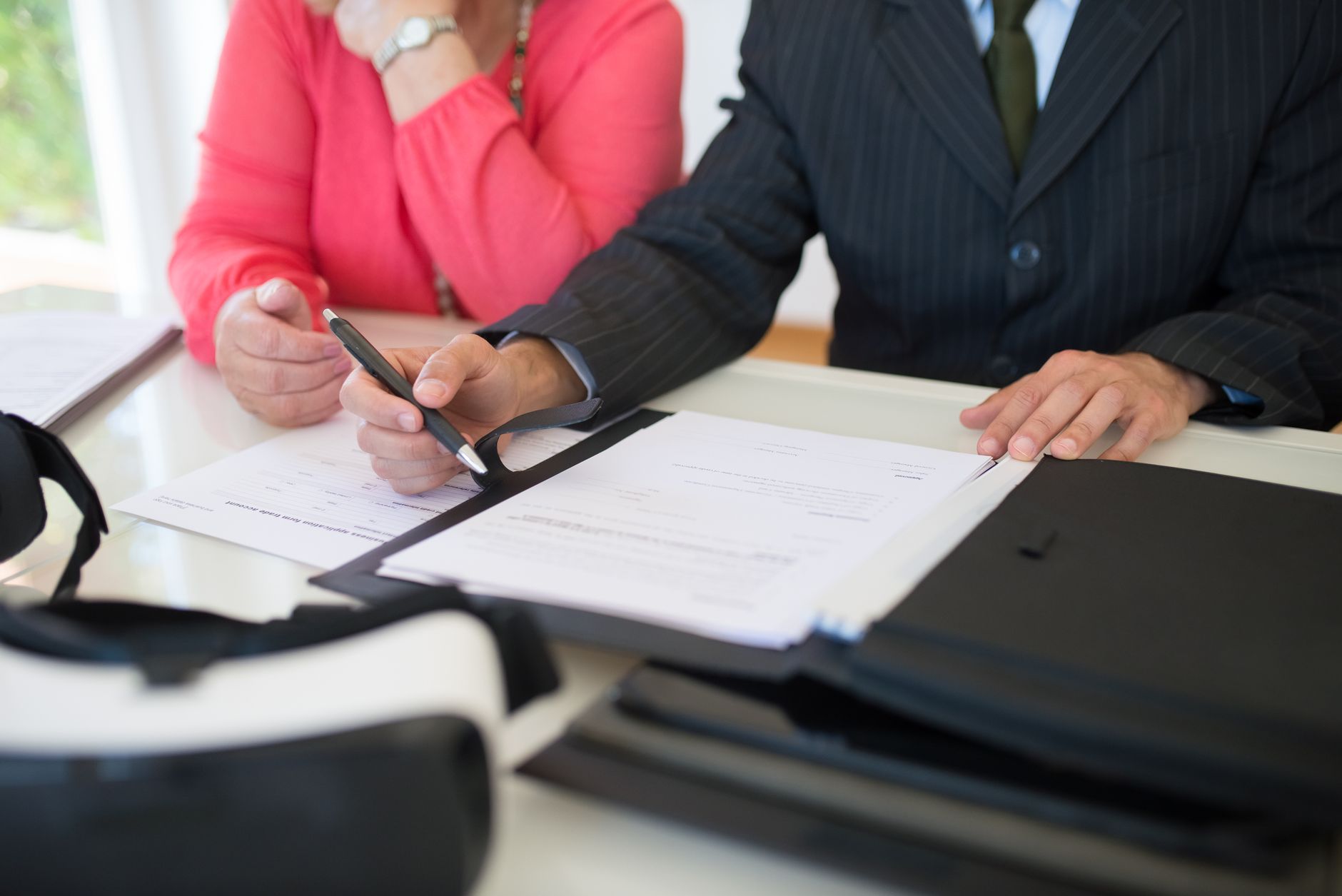 Business executive reviewing and signing financial documents at a desk