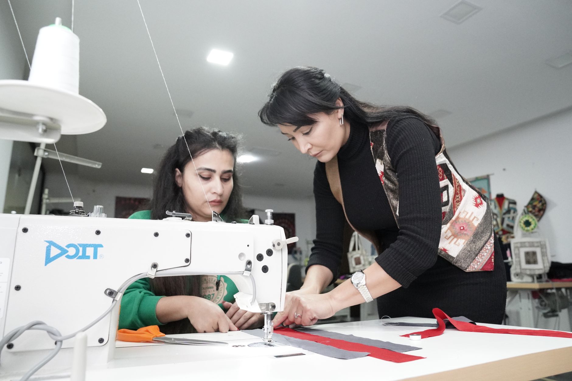 Young people learning to sew at a community workshop table