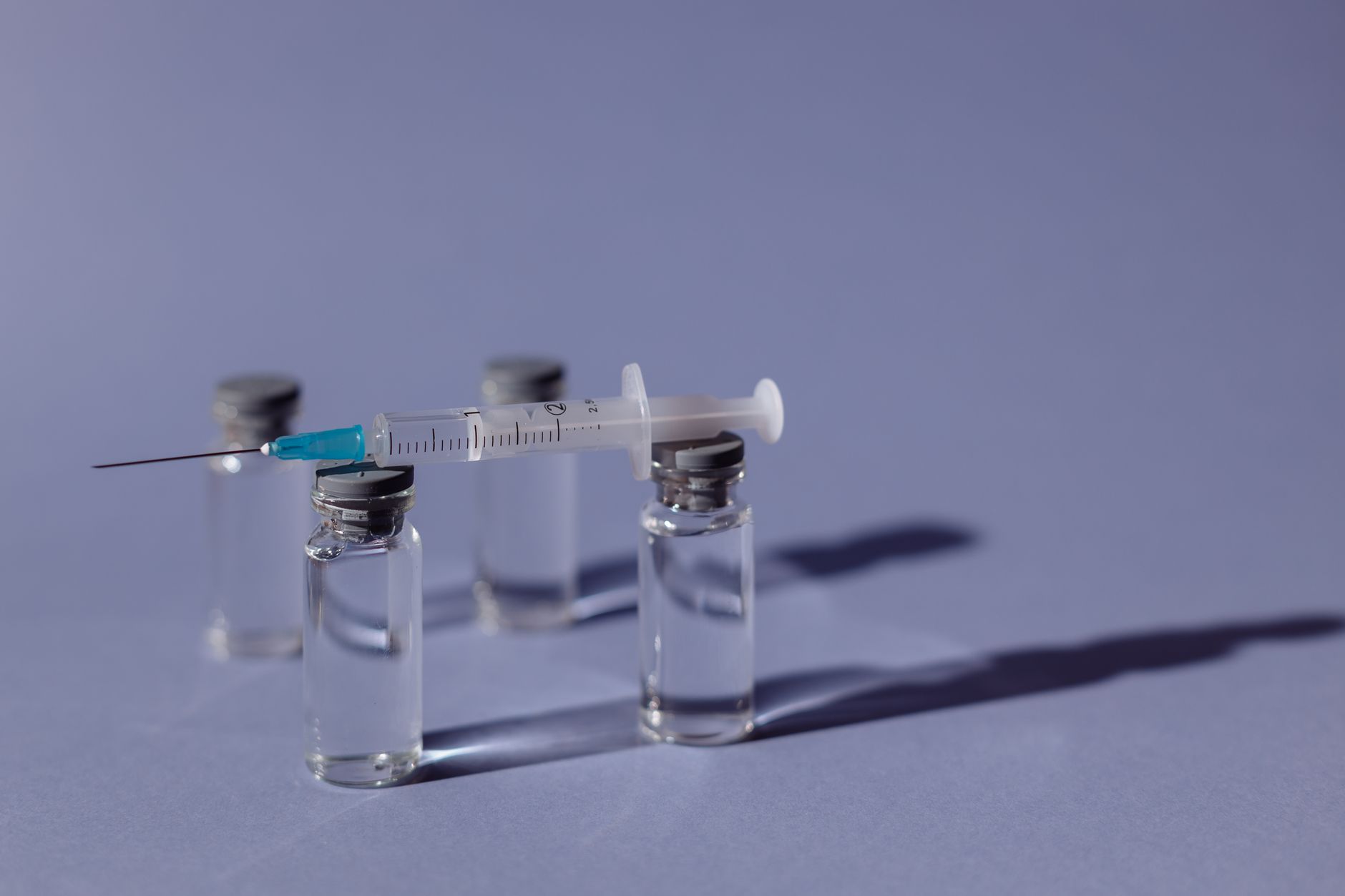 A medical professional preparing a vaccine syringe in a clinical setting
