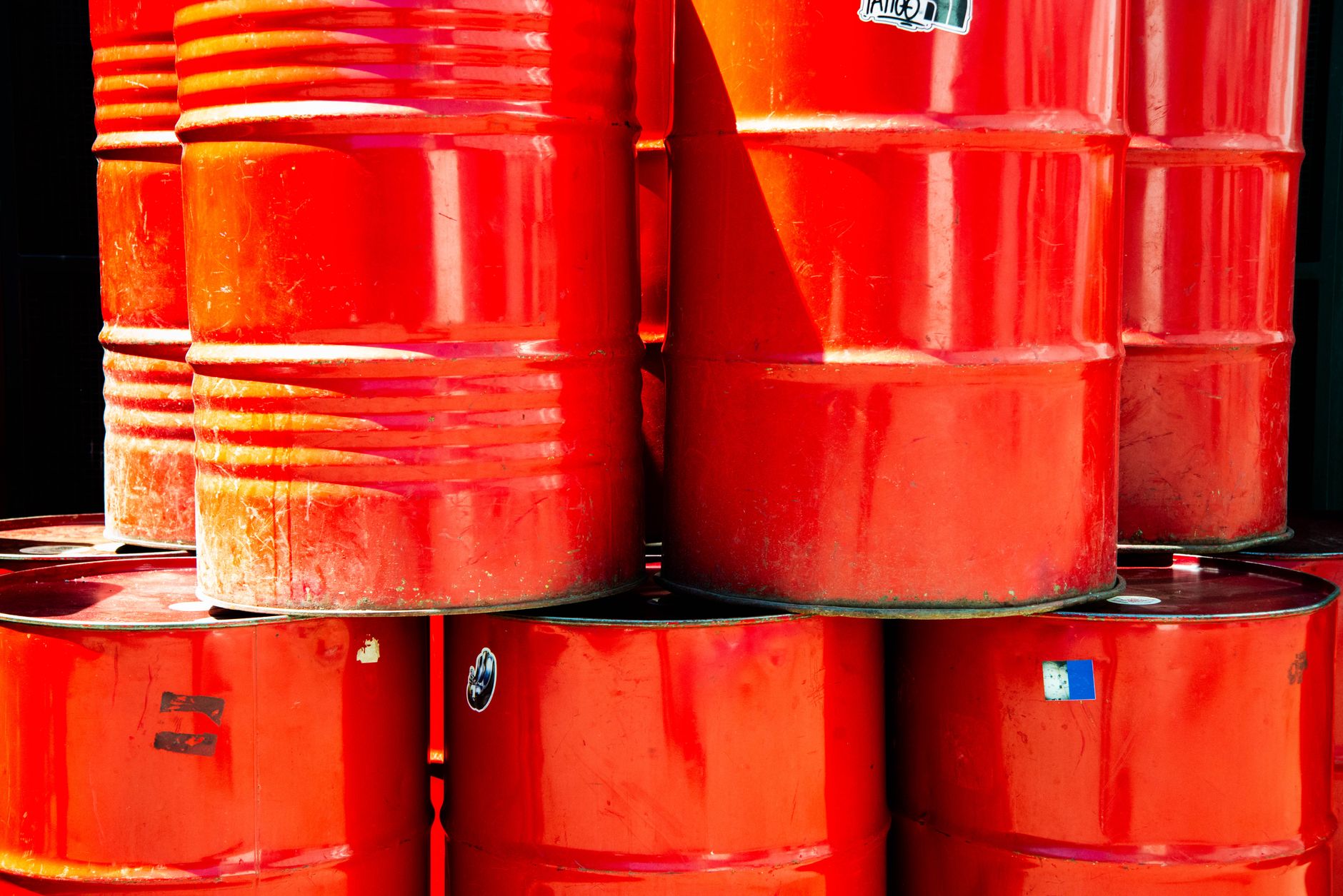 Industrial oil storage barrels representing crude price fluctuations affecting global markets