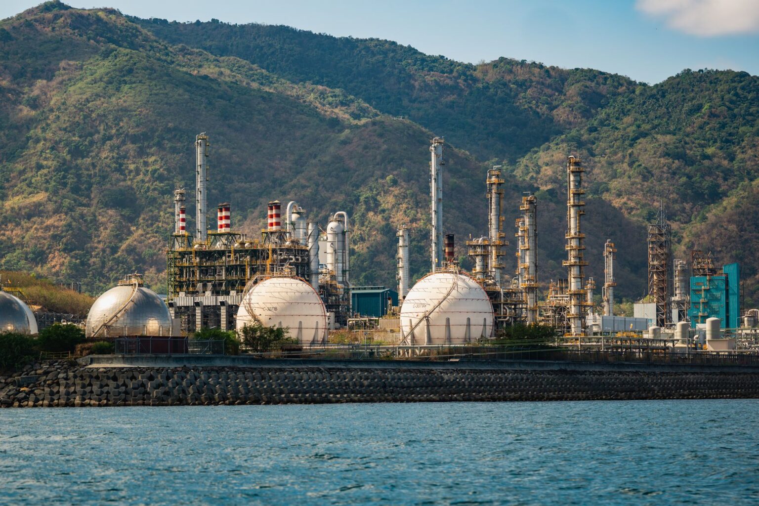 It’s not just Hormuz. Another war is providing fresh price shocks to fuel and food. Large oil refinery with smokestacks and storage tanks at dusk