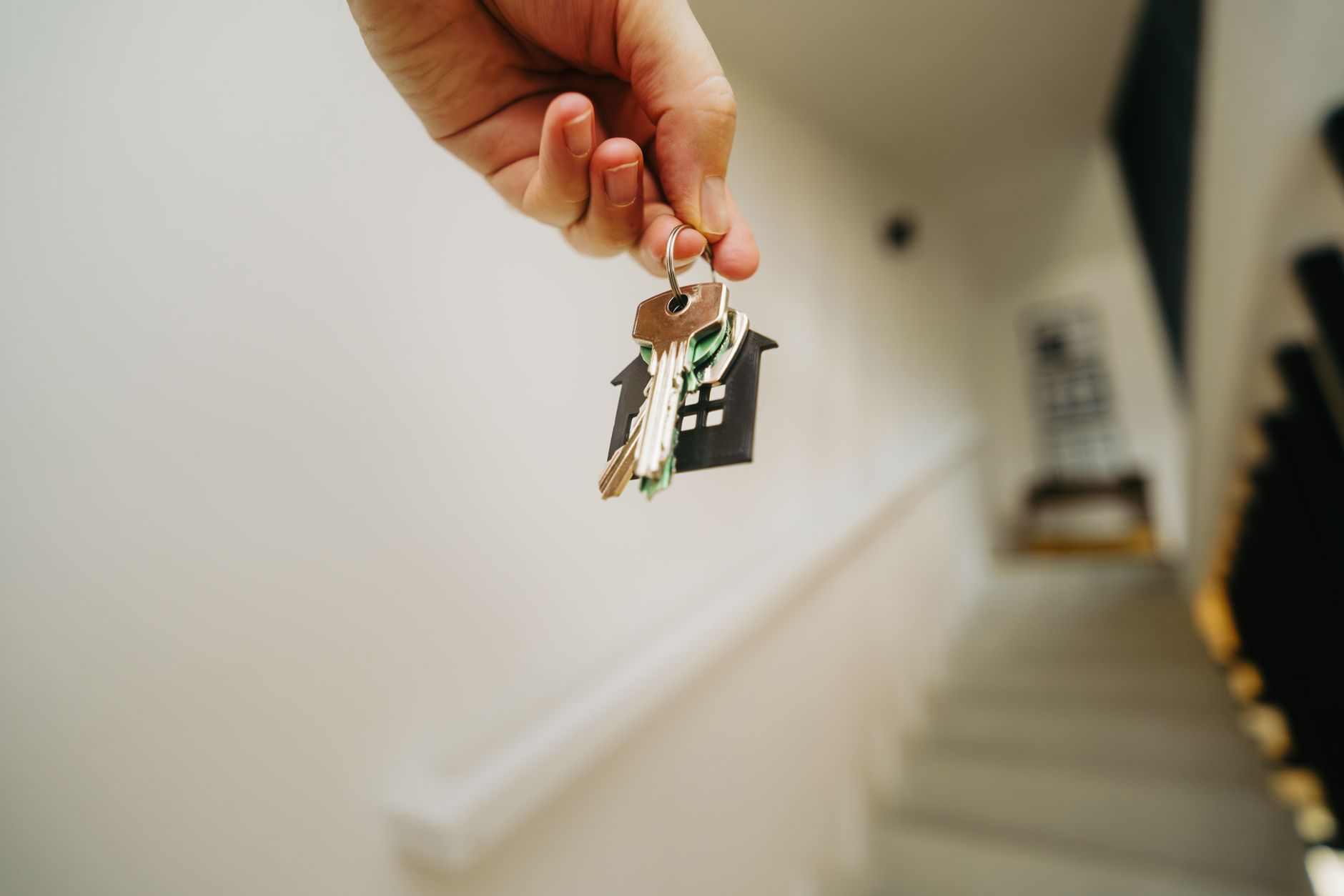 Person holding apartment keys outside a rental unit