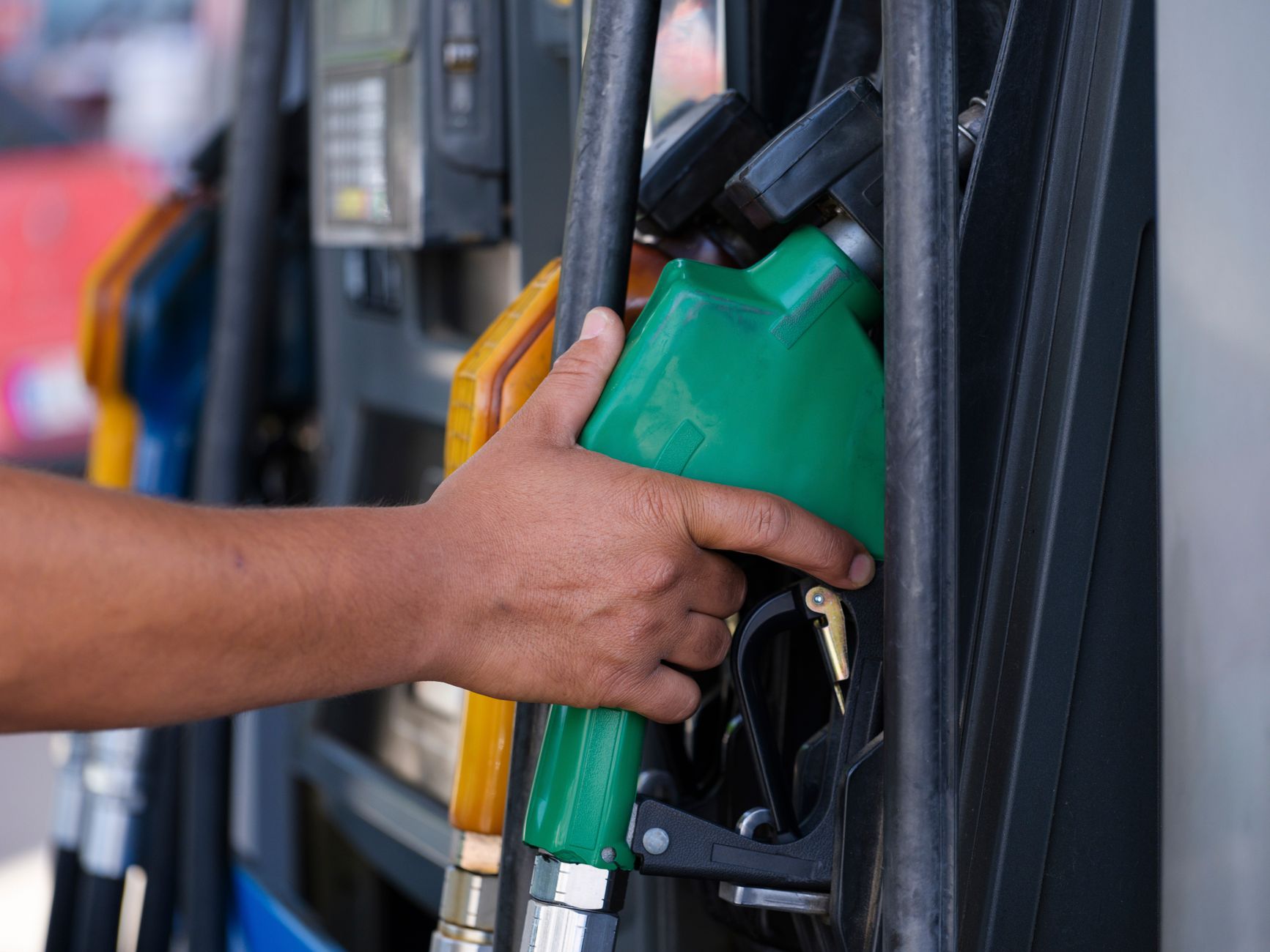 Consumer filling up at a gas station, illustrating the link between fuel costs and restaurant spending
