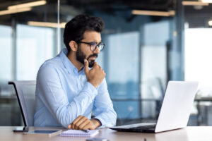 Investor reviewing stock market charts and portfolio options on a laptop