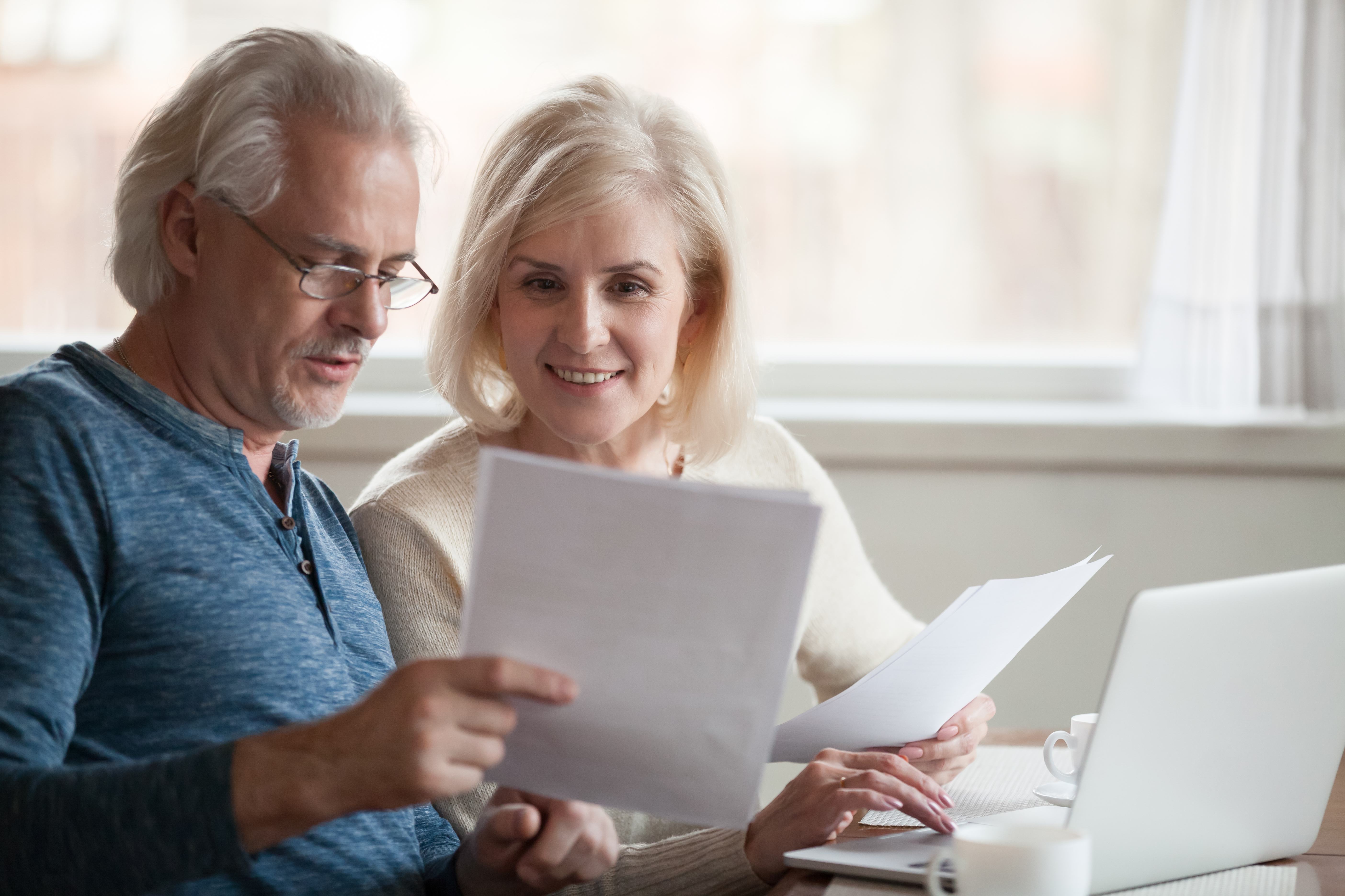 Older couple reviewing a financial calendar and planning documents at home