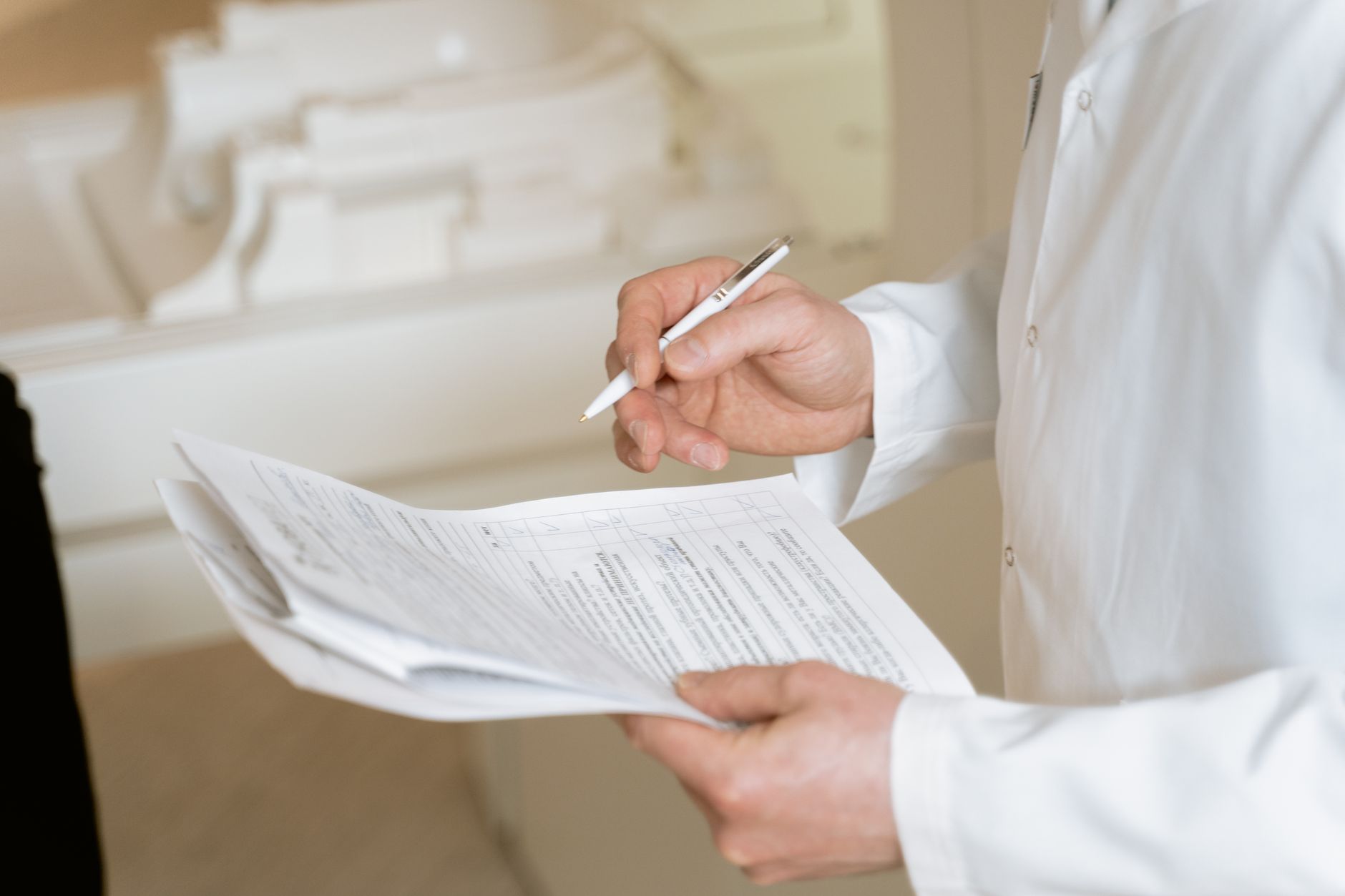 Doctor reviewing medical documents at a desk in a clinical setting