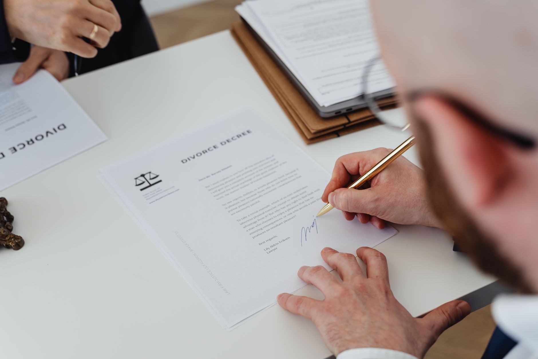 Two people shaking hands over documents at a conference table
